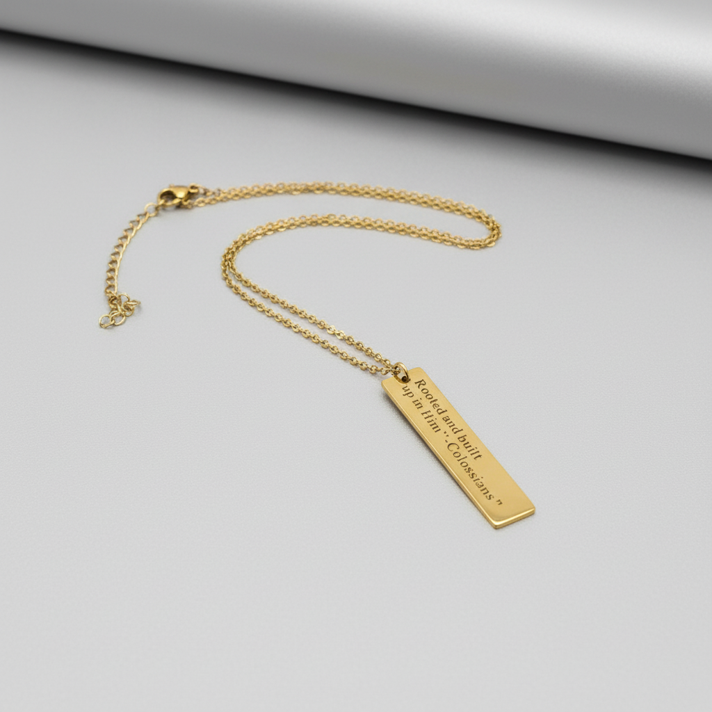 Gold necklace with a bar pendant on a white background