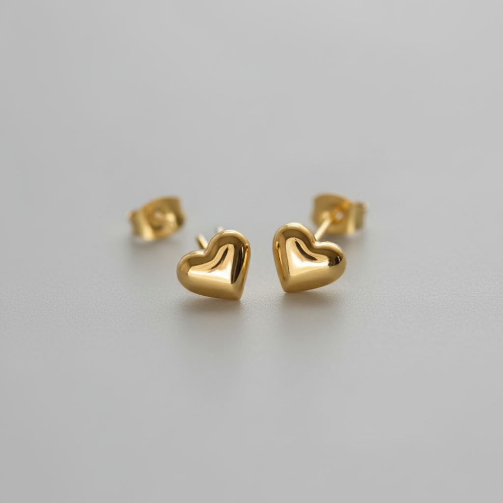 Gold heart-shaped earrings on A WHITE BACKGROUND