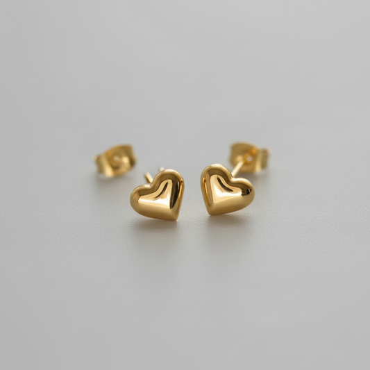 Gold heart-shaped earrings on A WHITE BACKGROUND