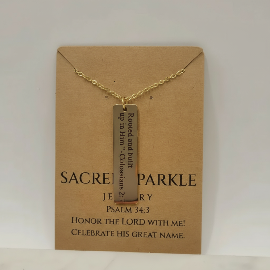 Gold necklace with a bar pendant on a 'Sacred Sparkle' card.