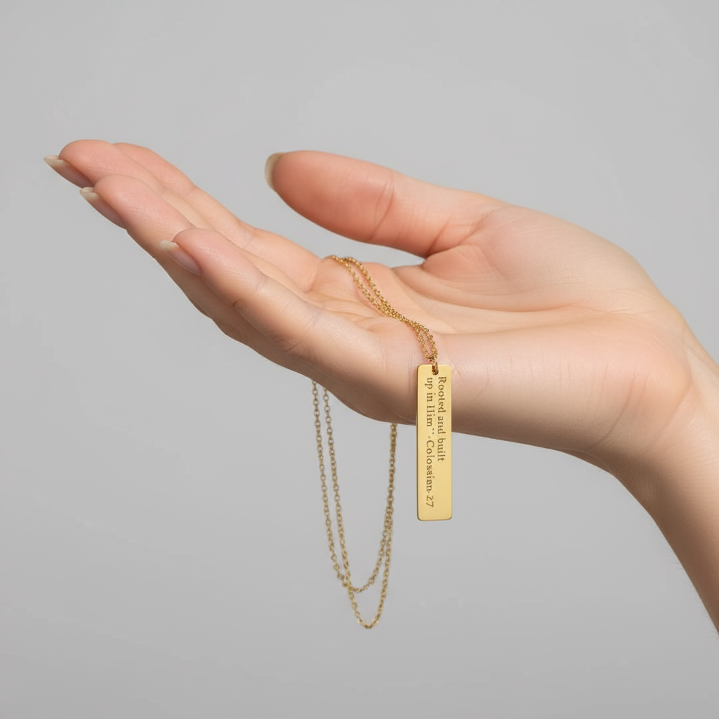 Gold necklace with a bar pendant on a white background 