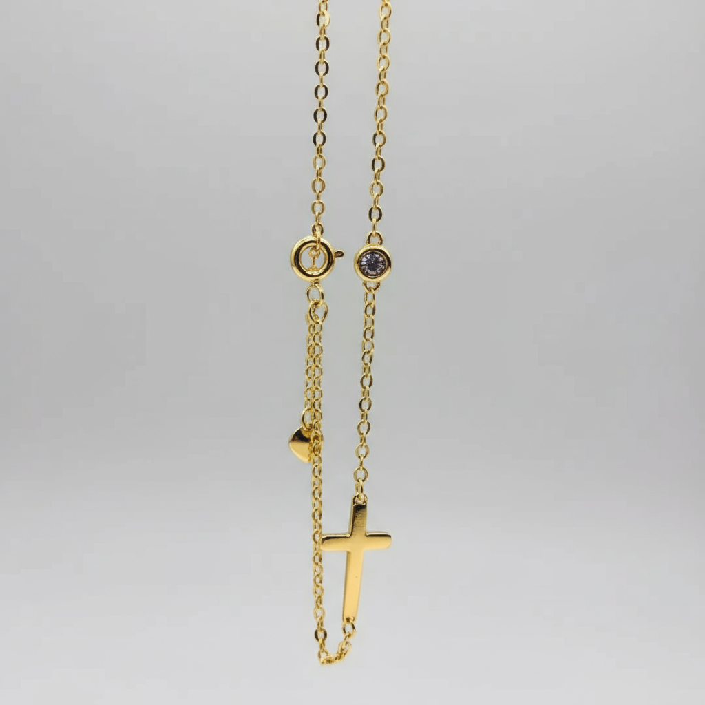 Gold necklace with a small cross pendant on a white background