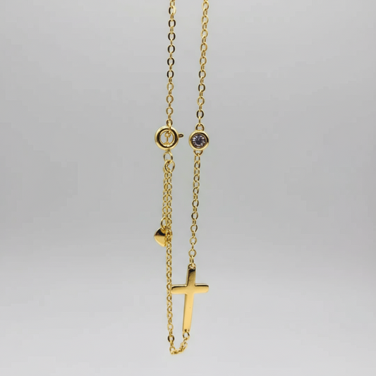 Gold necklace with a small cross pendant on a white background