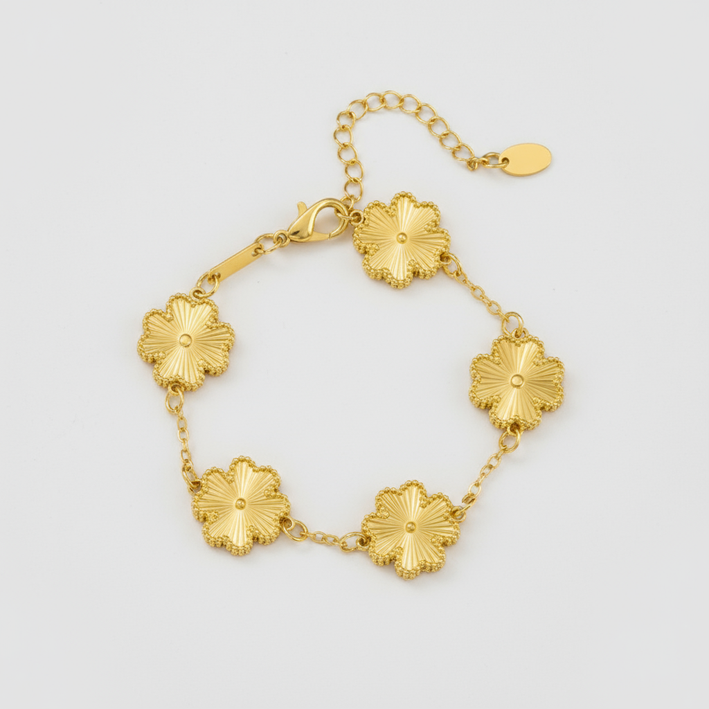 Gold bracelet with floral designs on a white background