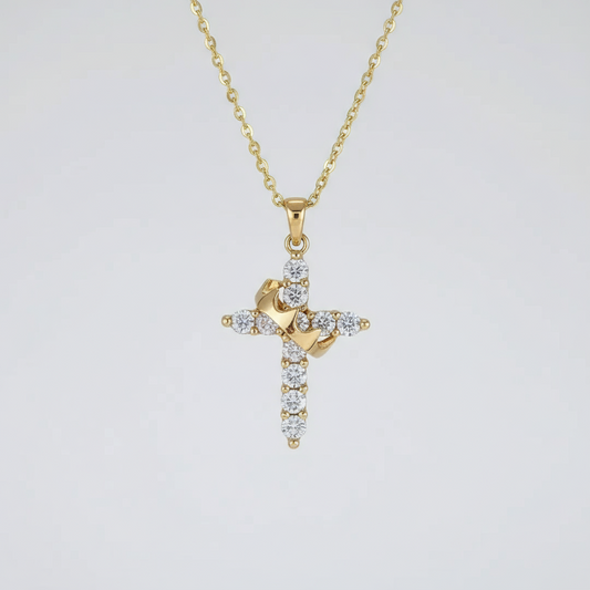 Gold cross necklace with diamonds on a light gray background