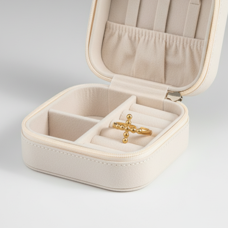 Gold ring with spherical design on a white fabric background