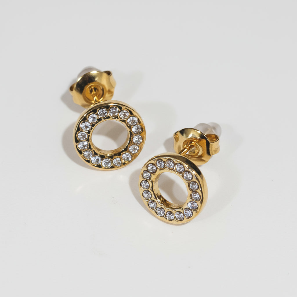 Gold earrings with circular design and embedded stones on a white background