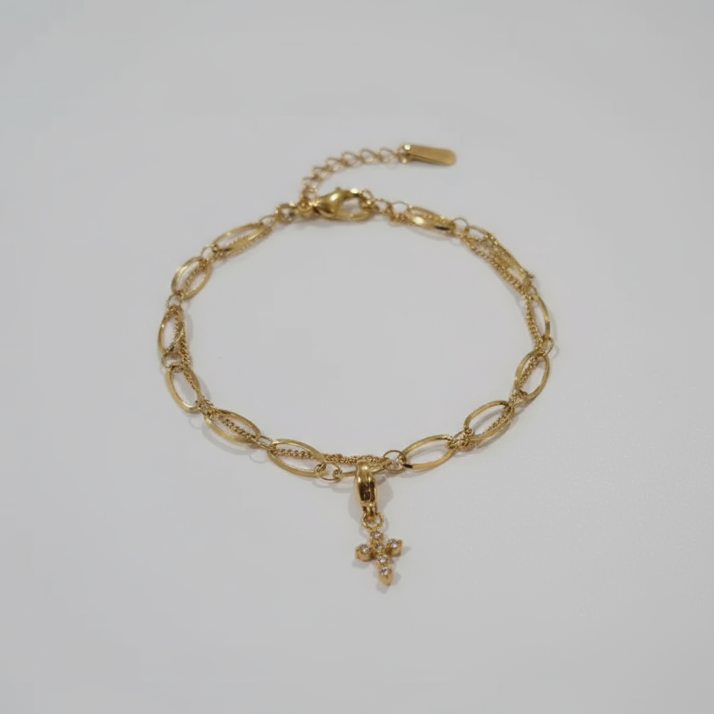 Gold chain bracelet on a wooden stand with a white background