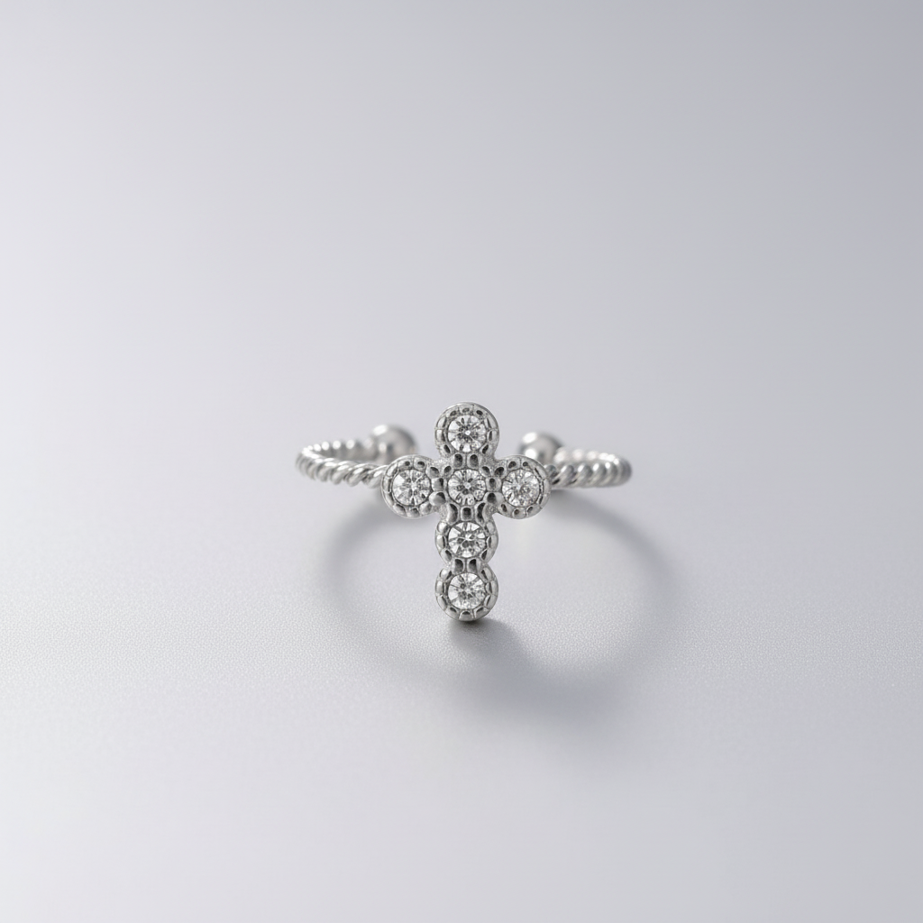 Silver cross-shaped ring with gemstones on a white background