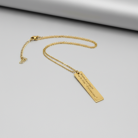 Gold necklace with a bar pendant on a white background