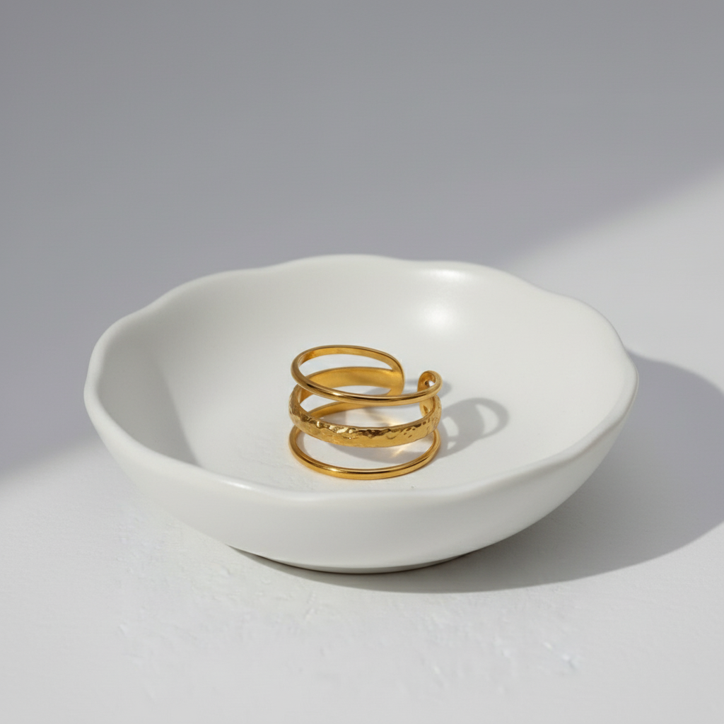 Gold ring with textured design on a white background